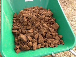 A wheelbarrow full of rocks, two barrow loads per strip  are coming out